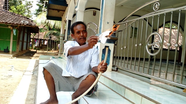 Sardi, 65, warga Dukuh Sambu, Desa Bendo, Nogosari, Ngemplak menunjukkan semburan gas dengan cara membakarnya dengan korek api, Minggu (25/4/2016). Warga menduga kandungan gas di bawah sangat besar. (Muhammad Ismail/JIBI/Solopos)