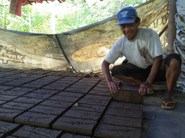 Pengrajin batu bata asal Jenangan, Ponorogo, Parlan, menata batu bata basah di rumah produksinya, Selasa (26/4/2016). (Abdul Jalil/JIBI/Madiunpos.com)