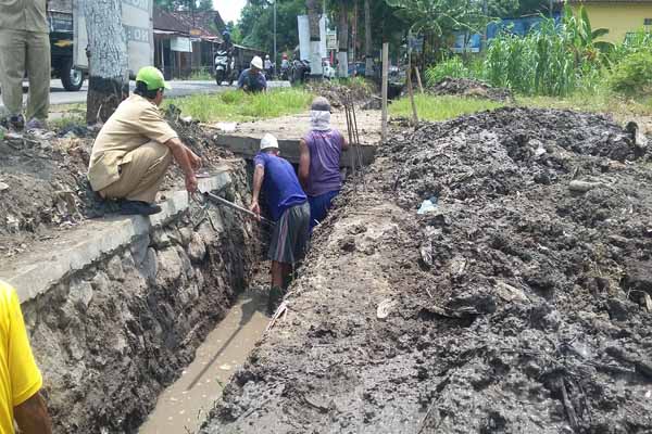 Petugas dari Dinas Sumber Daya Air saat melakukan pembersihan gorong-gorong di bawah plat beton di Jalan Parangtritis km 8,4 Tembi, Bangunharjo, Sewon, Bantul. Foto diambil Selasa (5/4/2016). (Yudho Priambodo/JIBI/Harian Jogja)