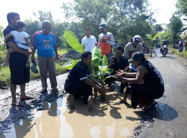 Warga Desa Sukorejo, Kecamatan Sukorejo, Ponorogo, menanam pohon pisang dan nisan di jalan penghubung Sukorejo-Sampung yang kondisinya rusak parah, Rabu (20/4/2016) pagi. (Abdul Jalil/JIBI/Madiunpos.com)