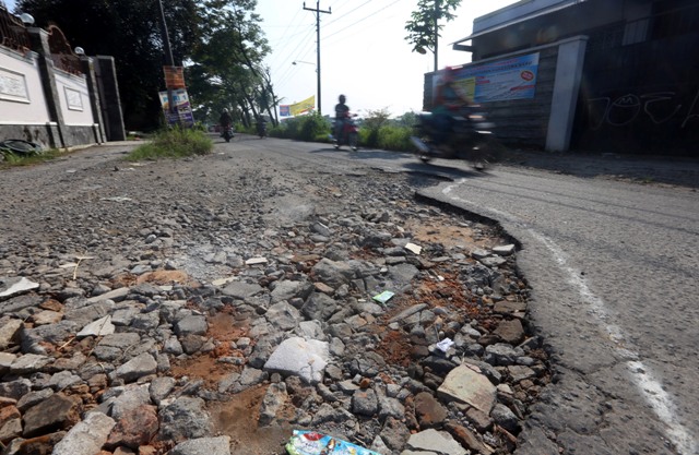Pengendara bermotor melintasi jalan rusak dan berlubang di Jl. Pakel, Banyuanyar, Banjarsari, Solo, Senin (25/4/2016). (Ivanovich Aldino/Solopos/Solopos)