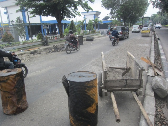 Pengguna jalan berlalu lalang di sekitar proyek peninggian Jl. Ahmad Yani tepatnya di depan Terminal Tirtonadi, Kamis (7/4/2016). Peninggian jalan tersebut dinilai bukan solusi mengurangi genangan di sekitar kawasan. (Chrisna Chanis Cara/JIBI/Solopos)