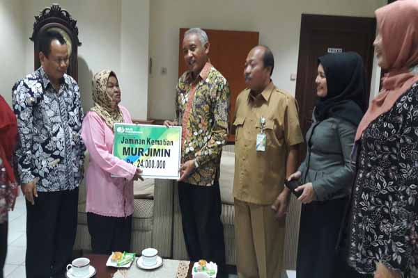 Bupati Sleman Sri Purnomo menyerahkan santunan jaminan kematian kepada ahliwaris peserta BPJS Ketenagakerjaan, kemarin. (Abdul Hamid Razak/JIBI/Harian Jogja)