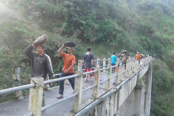 Warga dan relawan bergotong royong mengangkat batu untuk membenahi longsoran yang merusak jaringan pipa air bersih di Kawasan Sabo Dam Kalikuning, Plunyon, Umbulharjo, Cangkringan, Sleman, Jumat (1/4/2016). (Foto istimewa)