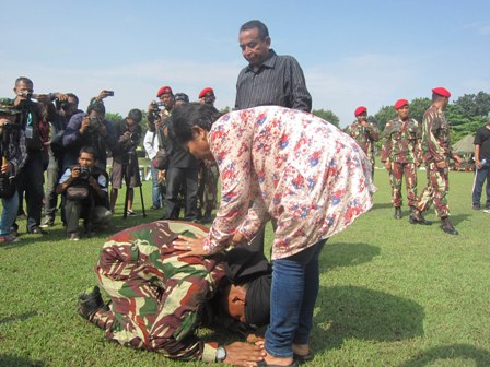 Dwi Adi bersimpuh di kaki ibundanya seusai mencetak rekor Muri, di Lapangan Makopassus Grup 2 Kandang Menjangan, Kartasura, Senin (4/4/2016). (Iskandar/JIBI/Solopos)