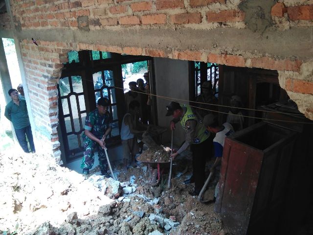 Aparat TNI, Polri, dan warga bergotong royong membersihkan material longsoran di rumah milik Lamio RT 001/RW 001 Desa Gedangan, Ngrayun, Ponorogo, Sabtu (9/4/2016). (Istimewa)
