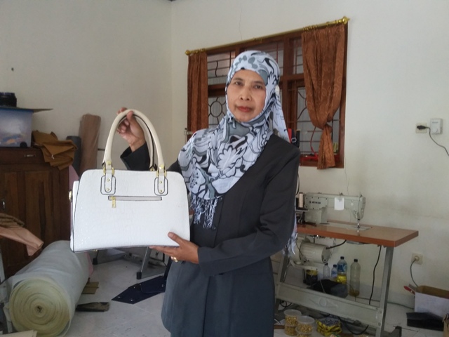 Kepala Sekolah Luar Biasa Dharma Wanita Jiwan Sri Florenty memamerkan produk kerajinan hasil karya siswa sekolah setempat, Rabu (23/3/2016). (Abdul Jalil/JIBI/Madiunpos.com)