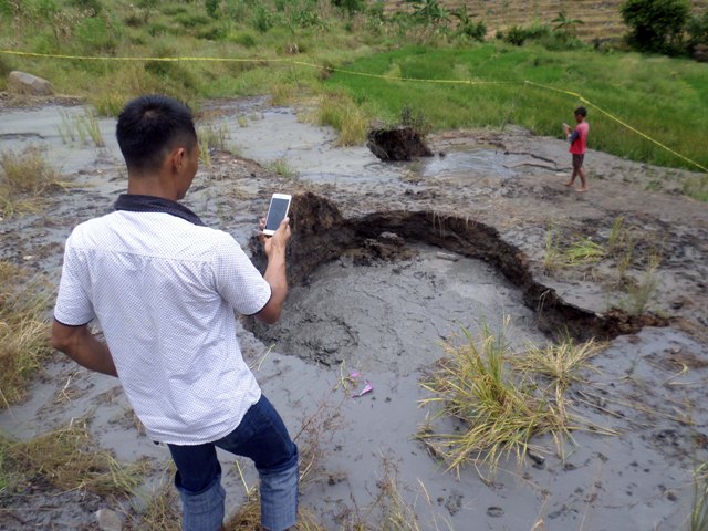 Pengunjung menerobos garis polisi yang dipasang di semburan air bercampur lumpur di Desa Jari, Gondang, Kabupaten Bojonegoro, Jawa Timur, Minggu (10/4/2016). (JIBI/Solopos/Antara/Aguk Sudarmojo)
