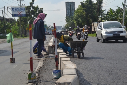 Sejumlah pekerja tengah memasang pembatas atau median jalan di Jalan Raya Solo-Sukoharjo mulai Simpang Empat Jln. Ciu hingga Simpang Empat Bulakrejo, Senin (18/4/2016)). (Bony Eko Wicaksono/JIBI/Solopos)