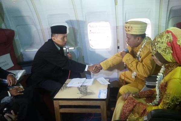 Pasangan pengantin nikah masal melaksanakan ijab kabul di dalam pesawat Boeing 737, dalam serangkaian HUT Sekolah Tinggi Teknologi Kedirgantaraan (STTKD) bekerjasama dengan Forum Taa’ruh Indonesia, Senin (4/4/2016). (Yudho Priambodo/JIBI/Harian Jogja)