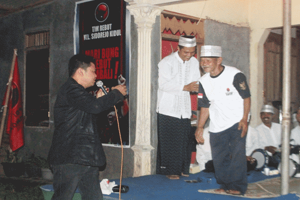 Ketua DPC PDI Perjuangan sekaligus Ketua DPRD Kota Salatiga, Teddy
Sulistio (kiri) usai memberikan kaos PDIP kepada Suroso pada acara
roadshow balon wali kota dan wakil wali kota PDIP Salatiga di rumah
salah seorang warga di Dusun Kluwing, Desa Kalibening, Tingkir, Salatiga, Kamis
(7/4/2016) malam. (Imam Yuda Saputra/JIBI/Semarangpos.com)