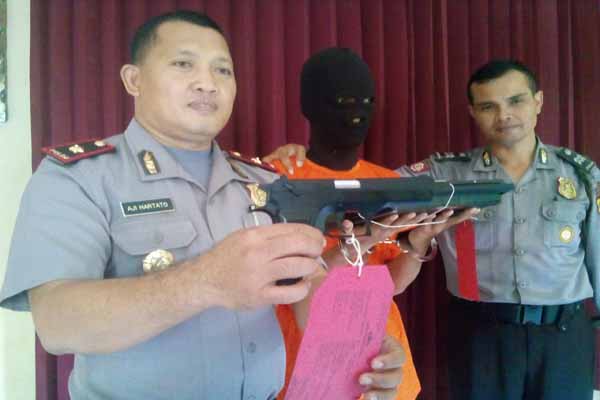 Kapolsek Bulaksumur Kompol Aji Hartato (kiri) menunjukkan senjata airgun yang digunakan tersangka Rizki (tengah) untuk merampok seorang pelaku jual beli online, Rabu (6/4/2016). (Sunartono/JIBI/Harian Jogja)