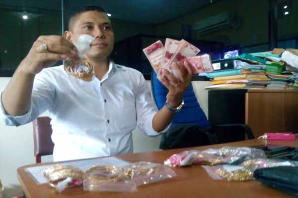 Petugas Polres Sleman menunjukkan uang tunai dan emas yang merupakan barang bukti kasus pencurian tiga kilogram emas, Senin (11/4/2016). (Sunartono/JIBI/Harian Jogja)
