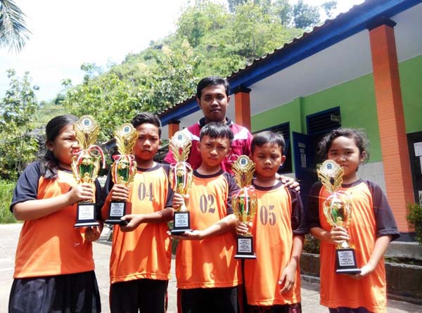 Sejumlah siswa SD Negeri Plumpit didampingi pelatihnya Isrori Teguh Aprianto memperlihatkan piala O2SN tingkat Kabupaten Gunungkidul dari cabang catur, Kamis (21/4/2016). (David Kurniawan/JIBI/Harian Jogja)