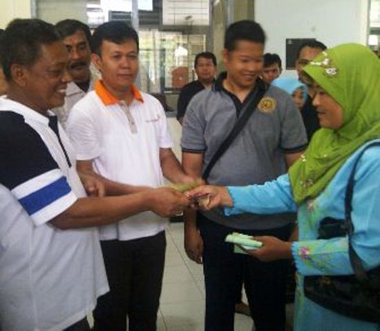 Bupati Pacitan Indartato memberikan bantuan PKH kepada kepada salah seorang penerima bantuan, Sabtu (23/4/2016). (pacitankab.go.id)
