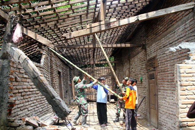 Prajurit TNI dan BPBD Trenggalek membantu warga membongkar rumah yang terancam longsor di Desa Pucanganak, Kecamatan Tugu, Trenggalek, Jawa Timur, Jumat (15/4/2016). (JIBI/Solopos/Antara/Destyan Sujarwoko)