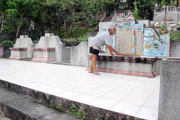 Samidi sedang membersihkan makam di kompleks pemakaman Gunung Sempu II, Bantul, Sabtu (2/4/2016). (Kusnul Isti Qomah/JIBI/Harian Jogja)