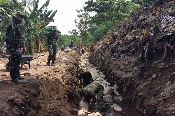 Anggota TNI dan masyarakat saat melakukan pembangunan fondasi dalam kegiatan Pra TMMD yang berlangsung di Dusun Citran, Jagalan, Banguntapan, Bantul, Jumat (22/4/2016). Dalam perencanaan kegiatan TMMD ini akan membangun talut dan membuat jalan alternatif bagi warga setempat. (Yudho Priambodo/JIBI/Harian Jogja)