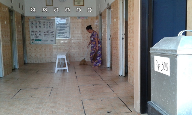 Pengelola MCK komunal Tri Tunggal di RT 003/RW 001 Kelurahan Semanggi, Pasar Kliwon, Kasmi, membersihkan lantai, Senin (1/8/2016). Pengelola mematok tarif masuk MCK senilai Rp300-Rp500 per orang. (Irawan Sapto Adhi/JIBI/Solopos)
