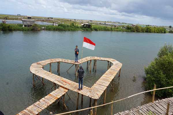 Objek wisata Pantai Pasir Kadilangu, Jangkaran, Temon menawarkan keunikan kreasi beragam stan dari bambu di sisi mangrove dan laut selatan Jawa. Jembatan cinta merupakan salah satu spot favorit bagi sebagian besar pengunjung untuk berfoto ria, Senin(22/8/2016). (Sekar Langit Nariswari/JIBI/Harian Jogja)