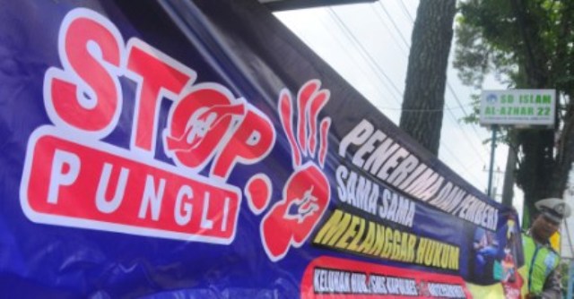 Polisi lalu lintas anggota Polres Salatiga menunjukan spanduk anti pungutan liar di Salatiga, Jateng, Selasa (25/10/2016). (JIBI/Solopos/Antara/Aloysius Jarot Nugroho)