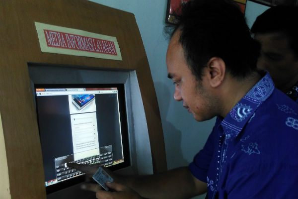 Seorang pegawai Badan Penanaman Modal dan Perizinan Terpadu (BPMPT) Kabupaten Kulonprogo menunjukkan cara mengakses pengurusan perizinan secara online melalui IzinKu, Jumat (23/12/2016). (Rima Sekarani I.N./JIBI/Harian Jogja)