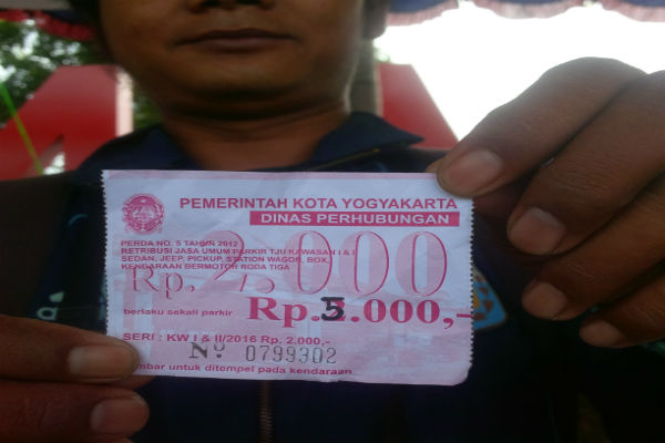 Warga menunjukan karcis parkir yang diganti angkanya dari Rp2.000 menjadi Rp5.000 di Embung Langensari.(Ujang Hasanudin/JIBI/Harian Jogja)