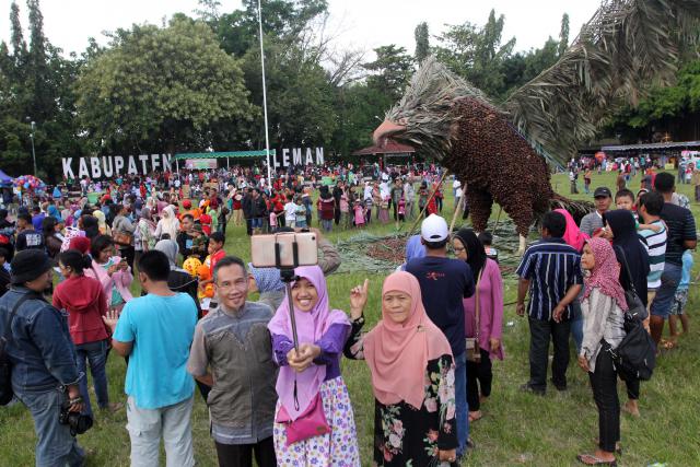 Warga berswafoto dengan maskot Elang Jawa yang dibuat dari rangkaian buang salak dan tanaman salak dalam Festival Salak Pondoh dan Mbok Jamu Gendhong yang diadakan di Lapangan Denggung, Sleman, DI. Yogyakarta, Minggu (25/12/2016). (Desi Suryanto/JIBI/Harian Jogja)