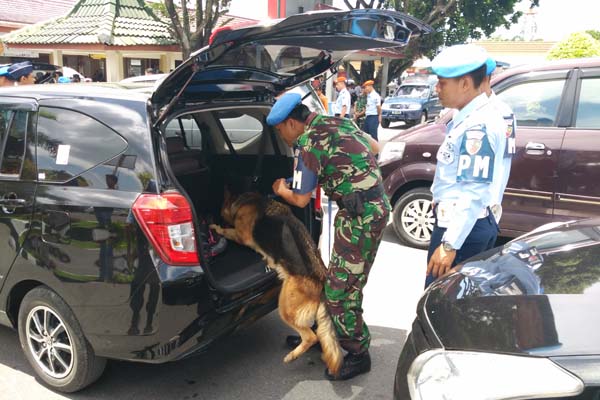 Petugas K-9 menggunakan anjing pelacak saat melakukan pengecekan terhadap kendaraan pengunjung, Kamis (22/12/2016). (Yudho Priambodo/JIBI/Harian Jogja)