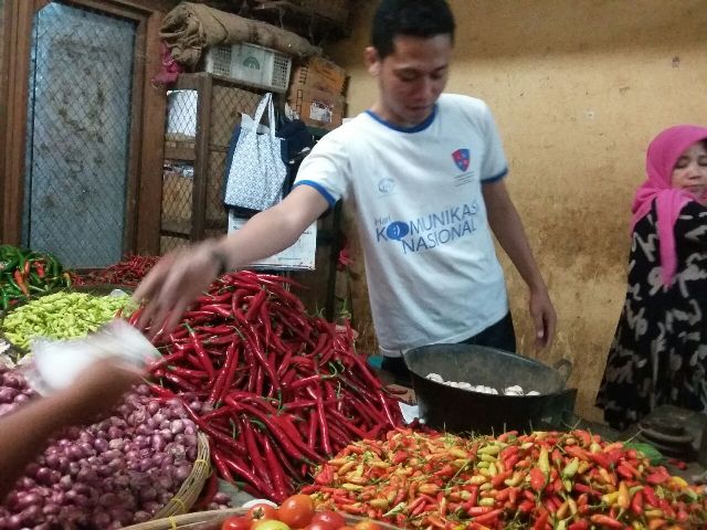 Seorang pedagang cabai dan sayuran di Pasar Songgolangit Ponorogo melayani pembeli, Jumat (30/12/2016). (Abdul Jalil/JIBI/Madiunpos.com)