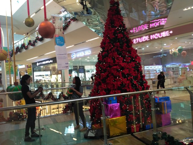 Pengunjung The Park Mall Solo Baru, Tora Agung Nugroho, memotret rekannya, Radi Russeta Dewi, di pohon natal yang terletak di lantai II, Jumat (23/12/2016). (Danur Lambang P/JIBI/Solopos)
