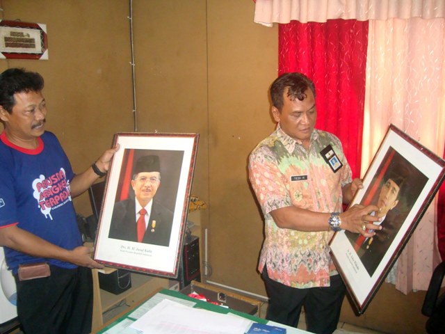 Sekretaris DPU Sragen, Tedi Rosanto (kanan), menunjukkan foto Presiden dan Wapres yang berlatar belakang bendera warna merah saja yang tadinya terpasang di dinding ruang Kantor DPU Sragen, Selasa (20/12/2016). (Tri Rahayu/JIBI/Solopos)