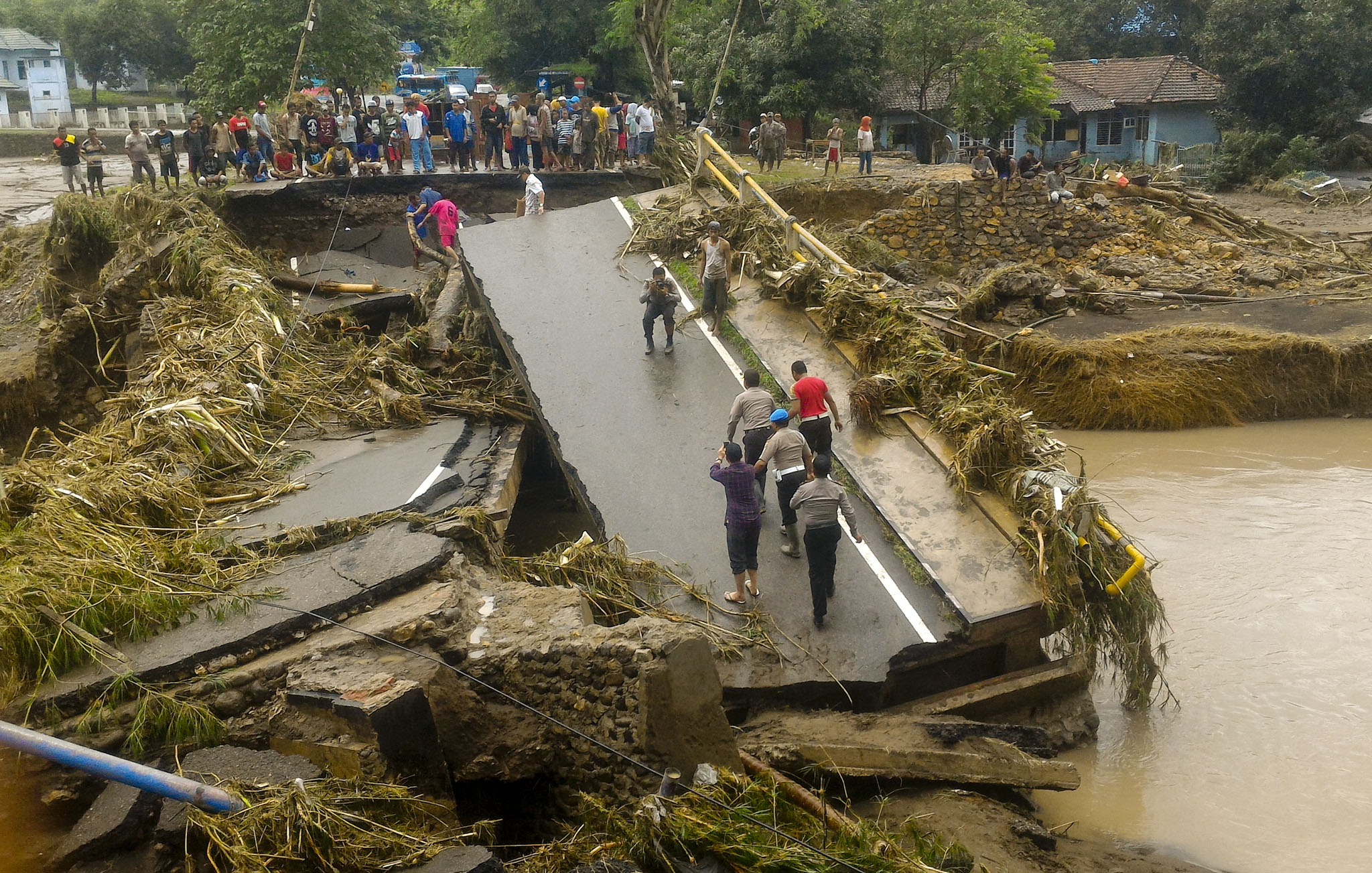 Warga berada dekat jembatan yang ambruk diterjang banjir di Kelurahan Kodo, Kecamatan Rasana'e Timur, Kota Bima, NTB, Kamis (22/12/2016). Banjir yang terjadi akibat meluapnya air sungai Padolo ini melumpuhkan seluruh aktifitas warga di Bima. (JIBI/Solopos/Antara/Didin)