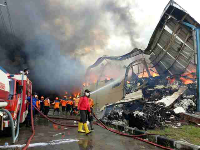 Tim pemadan kebakaran dari Soloraya bekerja keras mematikan api yang menghanguskan gudang bahan baku milik PT DMST I, Tunjungan, Sambungmacan, Sragen, Rabu (21/12/2016). Pemadaman kebakaran itu diperkirakan akan butuh waktu hingga Kamis (22/12/2016) karena banyaknya bahan baku berupa kapas, benang, dan kain yang terbakar. Tim pemadam kebakaran masih kesulitan menjangkau bagian tengah gudang karena terhalang tembok. (Moh. Khodiq Duhri/JIBI/Solopos)
