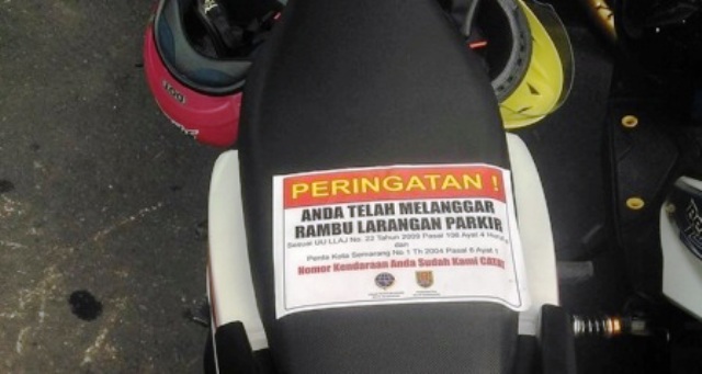 Sepeda motor yang terparkir di kawasan terlarang di Simpang Lima, Kota Semarang, Jateng digembok rodanya dan ditempeli stiker oleh petugas Dishubkominfo Kota Semarang, Senin (26/12/2016). (Facebook.com-Adi)