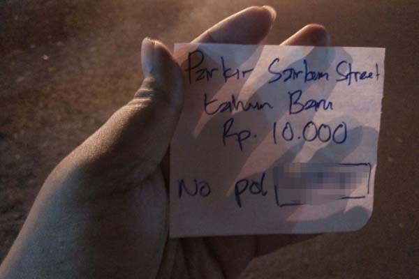 Karcis parkir Tahun Baru dengan tulisan tangan dari salah satu lokasi parkir liar di Jalan Pasar Kembang Jogja, Sabtu (31/12/2016) malam. (Holy Kartika N.S/JIBI/Harian Jogja)
