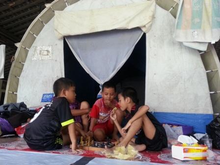 Tiga anak bermain catur di depan tenda pengungsian kebakaran di pendapa bekas TK Taman Putra Mangkunegaran, Minggu (25/12/2016) siang. (Mahardini Nur Afifah/JIBI/Solopos)