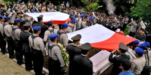 Sejumlah personel Polri menurunkan peti jenazah Brigadir Anumerta Andy Junaedy dan Brigadir Anumerta Mustofa Zahroni ke liang lahat di Taman Makam Pahlawan Giri Tunggal, Semarang, Jateng, Minggu (18/12/2016). (JIBI/Solopos/Antara/Aditya Pradana Putra)