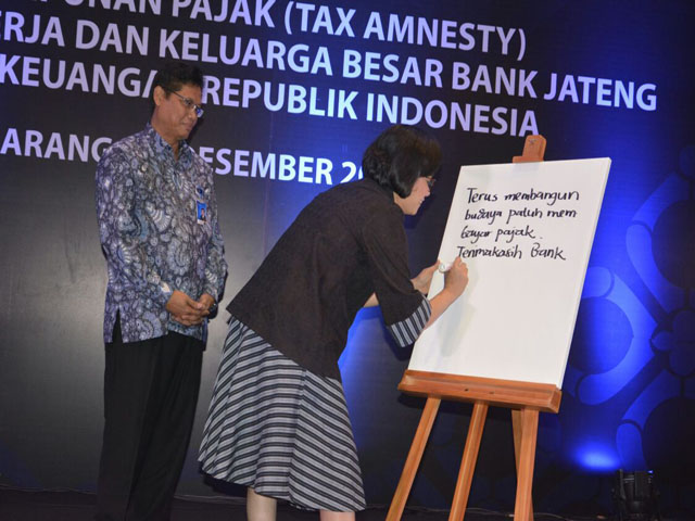 Menteri Keuangan Sri Mulyani (kanan), menuliskan kata-kata motivasi dalam sebuah papan saat acara Deklarasi Tax Amnesty Nasabah, Mitra Kerja, UMKM, dan Direksi Bank Jateng di Hotel Crown, Semarang, Kamis (29/12/2016). (JIBI/Semarangpos.com/Istimewa-Humas Bank Jateng)