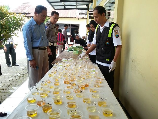 Anggota Polres Ponorogo mengecek urine dari anggota Polri yang mengikuti tes urine pencegahan narkoba, Rabu (28/12/2016). (Abdul Jalil/JIBI/Madiunpos.com)