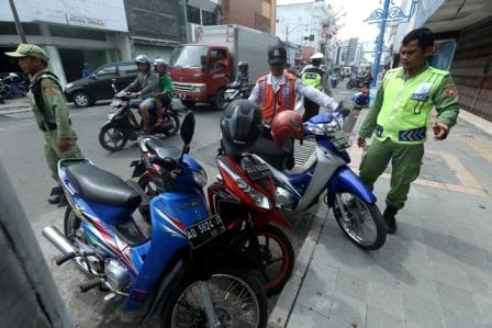 Petugas Dinas Perhubungan (Dishub) Kota Solo bersama anggota Linmas menata parkir kendaraan roda dua di Jl. Gatot Subroto, Singosaren, Solo, Jumat (6/1/2017). (Nicolous Irawan/JIBI/Solopos)