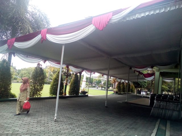Seorang pegawai negeri sipil (PNS) berjalan di kompleks Setda Klaten yang sudah dipasangi tenda untuk acara pengukuhan pejabat, Senin (9/1/2017). (Ponco Suseno/JIBI/Solopos)