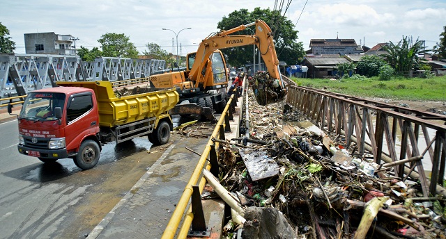 Operator ekskavator mengeruk sampah yang menumpuk di bawah jembatan Sungai Kanal Banjir Timur Semarang, Jateng, Selasa (14/2/2017). (JIBI/Solopos/Antara/R Rekotomo)