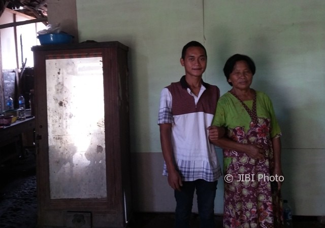 Rokim, 24, menggandeng Tampi, 67, yang kini menjadi istrinya di rumahnya, RT 009/RW 002, Desa Nampi, Kecamatan Gemarang, Kabupaten Madiun, Minggu (19/3/2017). (Abdul Jalil/JIBI/Madiunpos.com)
