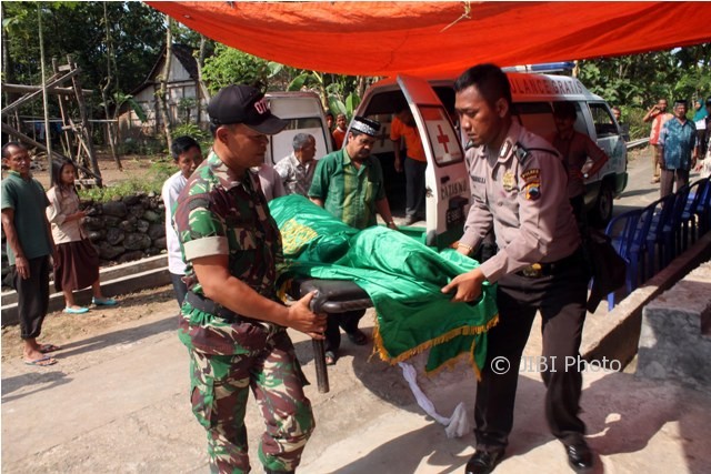 Aparat Polsek dan Koramil Kedawung mengangkat jenazah Nining dari mobil ambulans setibanya di rumah duka di Dukuh Kauman RT 003, Desa Bendungan, Kecamatan Kedawung, Sragen, Kamis (18/5/2017). (Tri Rahayu/JIBI/Solopos)