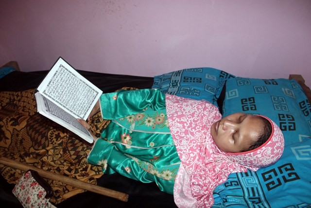 Sulami, 34, berbaring sambil mengaji ayat-ayat suci Alquran untuk mengisi Ramadan di kediamannya di Dukuh Selorejo Wetan RT 031, Desa Mojokerto, Kecamatan Kedawung, Sragen, Selasa (30/5/2017). (Tri Rahayu/JIBI/Solopos)