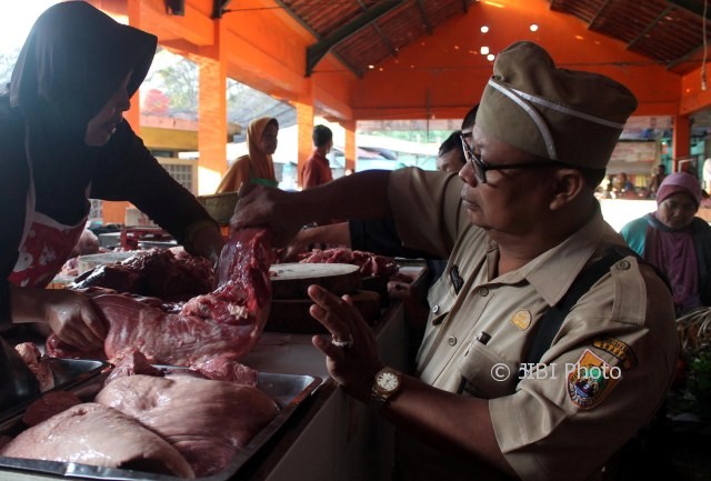 Kepala UPTD Disnakan Kecamatan Sragen Trieyono (kanan) memeriksa kualitas daging segar asal Boyolali di Pasar Bunder Sragen, Senin (19/6/2017). (Tri Rahayu/JIBI/Solopos)