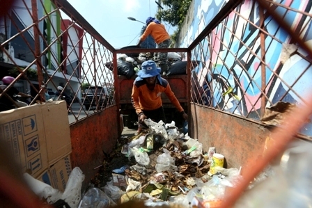 Ilustrasi petugas kebersihan memindahkan sampah dari gerobak ke mobil pengangkut sampah. (Nicolous Irawan/JIBI/Solopos)