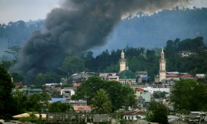 Asap mengepul dari bangunan yang terbakar saat pasukan Filipina menyerang militan Maute yang menguasai Kota Marawi, Jumat (16/6/2017). (JIBI/Solopos/Reuters/Romeo Ranoco)