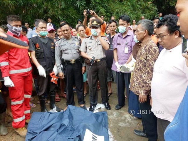Kapolsek Ngrampal AKP Budiyono (memakai masker) bersama warga melihat kondisi jenazah Haryanto, 11, bocah asal Srimulyo, Gondang, Sragen, yang ditemukan meninggal dunia di Sungai Klalimantras Dukuh/Desa Ngarum, RT 008, Kecamatan Ngrampal, Sragen, Selasa (13/6/2017). (Istimewa/Polsek Ngrampal)